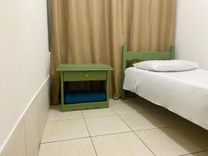 a small bedroom with a bed and a green nightstand at Casa no centro histórico de São João del- Rei in São João del Rei +14 photos