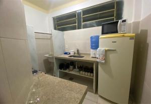 a small kitchen with a refrigerator and a sink at Casa no centro histórico de São João del- Rei in São João del Rei