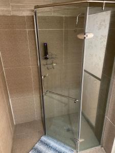 una ducha con puerta de cristal en un baño en Departamento Bonito cama Queen, con acceso privado, en Ramos Arizpe