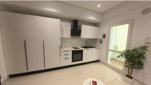 a kitchen with white cabinets and a potted plant at Farah in Sousse