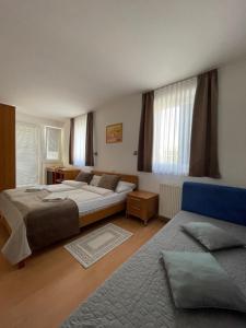 een slaapkamer met 2 bedden en een bank bij Garni Hotel Keltika in Izola