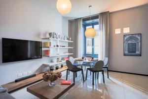 un salon avec une table, des chaises et une télévision dans l'établissement Palazzo Visconti - by MyHomeInComo, à Côme