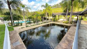 une vue aérienne d'une piscine avec des palmiers dans l'établissement ASA | Sítio Vô Tontini | Natureza | Quadra | Pisc., à Gaspar