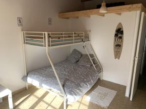 ein Schlafzimmer mit einem Etagenbett in einem Zimmer in der Unterkunft Maison de vacances , idéale pour famille avec accès plage et spa in Barbâtre
