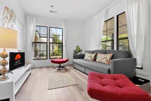 un salon avec un canapé gris et une chaise rouge dans l'établissement The Tilted Texan, à Buda