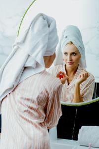 カサブランカにあるオウム パレス ホテル & スパの鏡の中で歯を磨いている女性