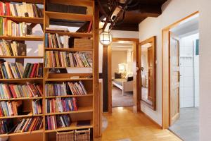 una biblioteca con estanterías de madera llenas de libros en Casa Rose Pere, en Hoffenheim