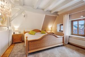 1 dormitorio con cama de madera y almohadas verdes en Casa Rose Pere, en Hoffenheim