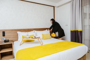 カサブランカにあるオウム パレス ホテル & スパのホテルの部屋のベッドの横に立つ女性