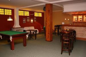 a room with a pool table and tables and chairs at Pousada Portal das Cerejeiras by Platanus in Campos do Jordão