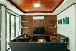 a living room with a couch and a television at Baan Viset Pool Villa Krabi in Ao Nang Beach
