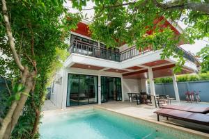 a villa with a swimming pool and a house at Baan Viset Pool Villa Krabi in Ao Nang Beach