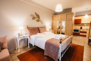 een slaapkamer met een groot wit bed en een keuken bij Αγροικια ΜΥΛΟΔΕΣΗ in Kalavrita