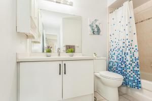 ein weißes Bad mit einem WC und einem Spiegel in der Unterkunft House of 3 Bed 3 Wash-Crib-King Bed-85' TV-Wrkspce in Oakville + 29 Fotos