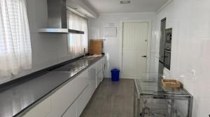 a large white kitchen with a glass counter top at LAIDA BEACH by Urdaibai Experience in Ibarrangelu