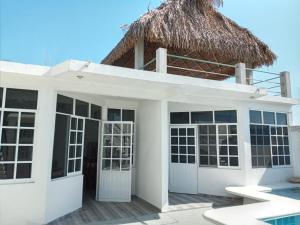 a white house with a thatched roof at Casa Mia in Cedro