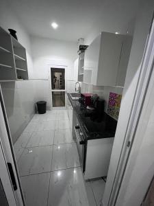 cocina con armarios blancos y suelo de baldosa en Keur joie, en Mbour