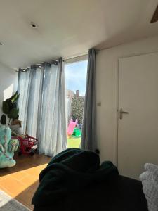 a bedroom with blue curtains and a window with a view at Le Luxembourg 1 in Thionville