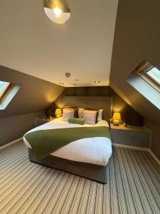 a bedroom with a large bed in a attic at Craigatin House & Courtyard in Pitlochry
