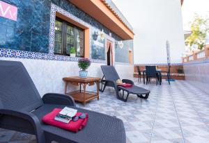 a patio with chairs and tables on a building at Ocean views "Las Garzas" in Sardina +46 photos