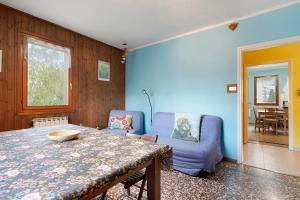 a living room with a table and a blue wall at Da Roby - Villa Carolina in Fenis