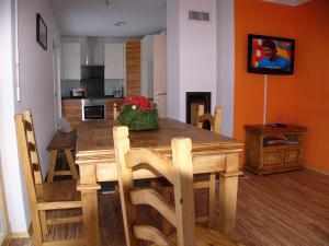 uma sala de jantar com uma mesa de madeira e cadeiras em Feriendorf Uorsin em Scuol