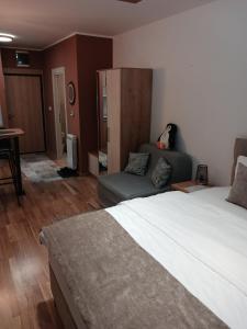 Un dormitorio con una cama grande y un sofá. en Studio DORA SS, en Stari Banovci