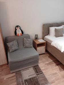 una sala de estar con un sofá y un juguete de pingüino en Studio DORA SS, en Stari Banovci