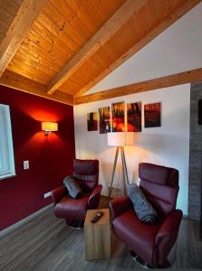 a living room with two chairs and a table at Ferienhaus Fichtelwichtel in Mehlmeisel +5 photos