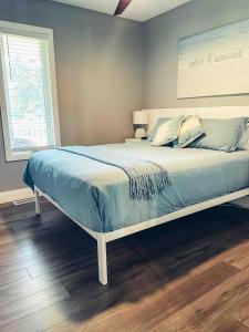 a bedroom with a large bed with blue sheets at Shores of Erie Guest House in Essex