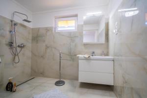une salle de bain avec douche et lavabo dans l'établissement Non stop apartman 1, à Kaposvár 13 autres photos