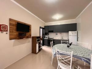 a kitchen and dining room with a table and chairs at Casa do amor, vc pode ir andando até a praia in Itapoa