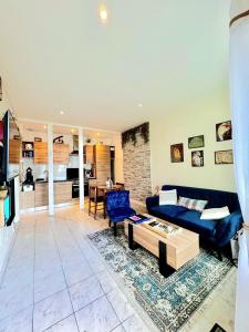 オーにあるL'App' Art, Jolie vue mer en RDC à 200 m de la plageの青いソファとテーブルのあるリビングルーム