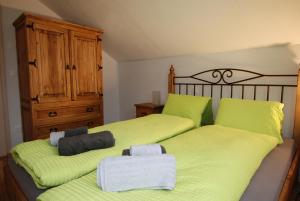 um quarto com 2 camas e lençóis de verde limão em Feriendorf Uorsin em Scuol