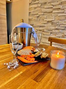 オーにあるL'App' Art, Jolie vue mer en RDC à 200 m de la plageの食べ物の皿とキャンドルとワイングラスが置かれたテーブル