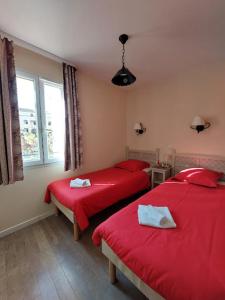 2 Betten in einem Zimmer mit roter Bettwäsche und einem Fenster in der Unterkunft Maison 3 pièces domaine golf Pont Royal in Mallemort