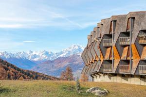 a building on a hill with mountains in the background at Ma Chérie-Lumière in Pila