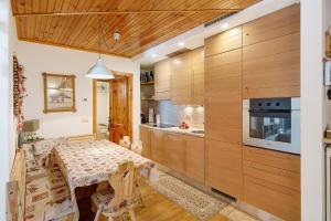 a kitchen with wooden cabinets and a table with chairs at Matteo's apartment by Alpenwhite in Livigno