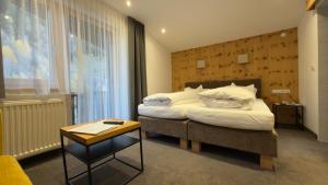 a hotel room with a bed and a table at Hotel Sailer in Sankt Anton am Arlberg