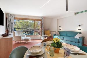 a living room with a blue couch and a table at Ma Chérie-Lumière in Pila