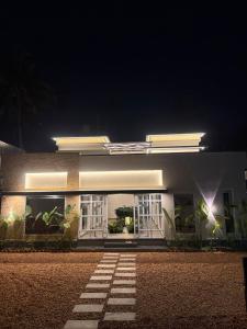Un bâtiment blanc avec des lumières allumées la nuit dans l'établissement Casa Linda Residency, à Varkala