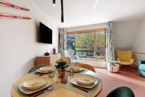 a dining room with a table and chairs and a window at Ma Chérie-Lumière in Pila