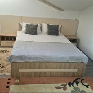 a bedroom with a large bed with white sheets and pillows at Square Apartment in Paraćin