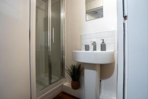 ein Badezimmer mit Waschbecken und Dusche in der Unterkunft Penthouse in Central Nottingham with Hot tub and Games in Nottingham + 27 Fotos