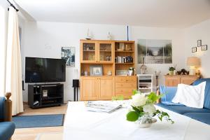 Ferienhaus Irle في Neukirchen: غرفة معيشة مع أريكة زرقاء وتلفزيون