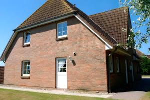 Ferienhaus Irle في Neukirchen: منزل من الطوب الأحمر مع باب أبيض
