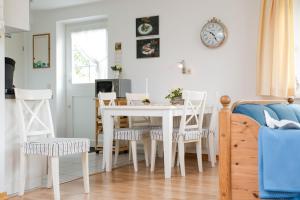 Ferienhaus Irle في Neukirchen: مطبخ وغرفة طعام مع طاولة وكراسي بيضاء +4 صور