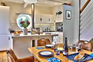 a kitchen with a wooden table with chairs and a dining room at Villa Saint Samson in Trégastel