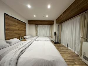 ein großes weißes Bett in einem Zimmer mit Fenster in der Unterkunft NEW PS508 Susukino Family Room in Wada