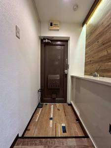 einen Flur mit brauner Tür und Holzboden in der Unterkunft NEW PS508 Susukino Family Room in Wada